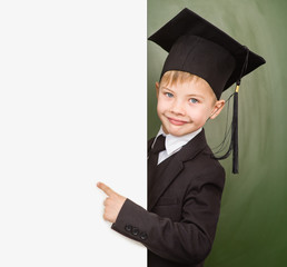 Boy in graduation hat pointing at blank placard