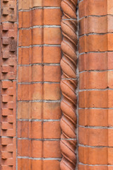 Sunlit red brick wall corner with iron ladder shadow. Abstract geometric composition