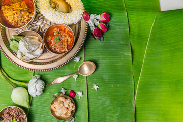 A set of treaditional northern Thailand's food, served in brass ware on banana leaves decorated with flowers.