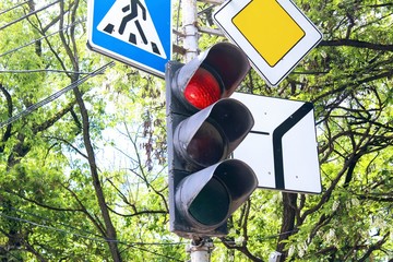 Traffic light and three road signs regulating the traffic in the city.