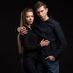 Young sexy couple portrait of a confident businessman showing presentation on a black background. Ideal for banners, registration forms, presentation, landings, presenting concept.