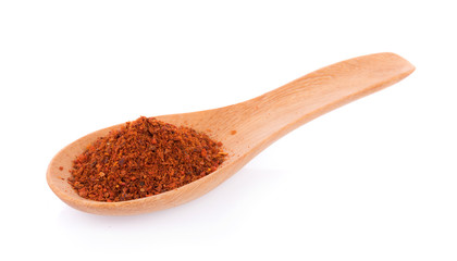 Pile of red paprika powder on spoon wooden