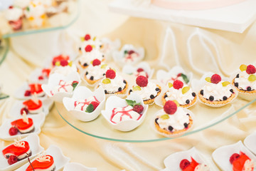 Delicious and tasty dessert table with cupcakes shots at reception closeup