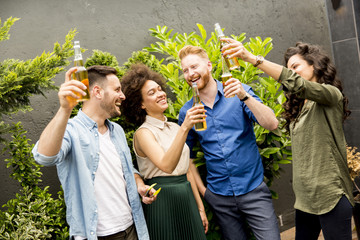 Friends having outdoor garden party toast with alcoholic cider drinks