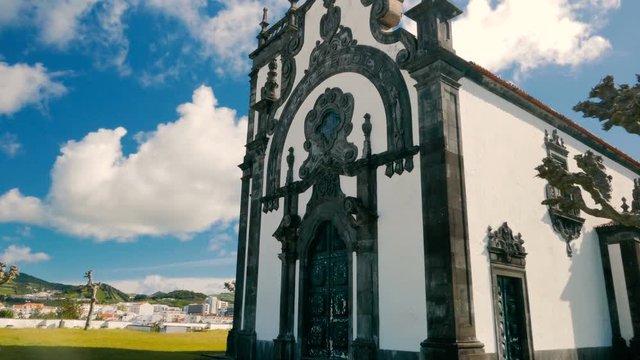 A gimbal of shot of the Ermida de Nossa Senhora Mae de Deus church in Ponta Delgada, The Azores, Portugal against a blue sky