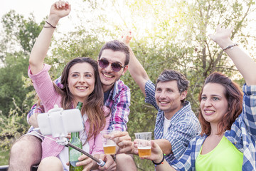 Happy group of young friends toasting with beer