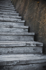 Old wooden stairs up outdoors with the stone