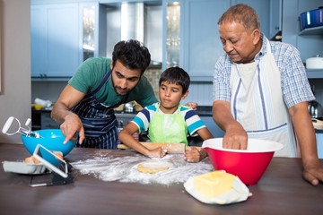 Man showing tablet to son while preparing food