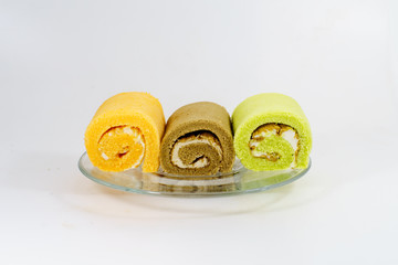 jam roll cake on glass dish on white background.