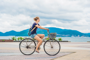 Fototapeta premium carefree woman with bicycle riding by the sea having fun and smiling