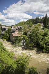 Fototapeta na wymiar Croatian village of Rastoke by a river canyon with wooden houses in a green landscape with trees and a waterfall, Croatia