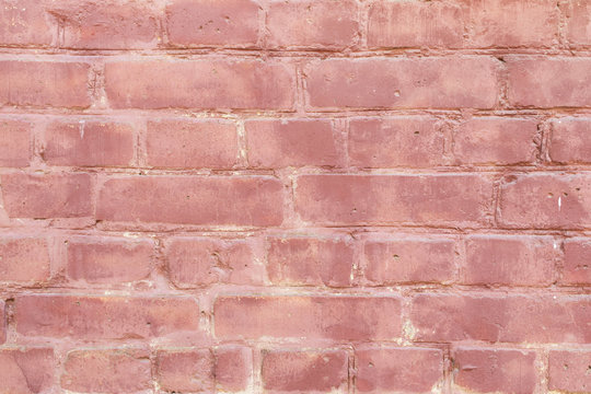 Pink old brick wall with paint, background texture close up