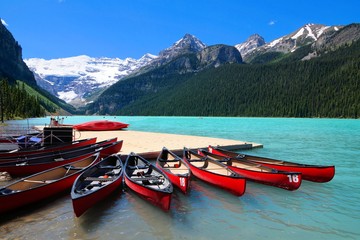 Red canoes in the blue waters of Lake Louise, Banff National Park, Alberta, Canada