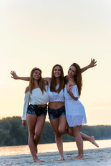 Three girls on beach posing