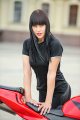 Freedom and style. Colorful portrait of a young woman with a red motorcycle.