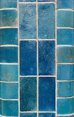 Blue ceramic tiles on a column in different shades including aqua, turquoise, light and dark