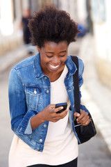 Attractive young african american woman laughing with mobile phone