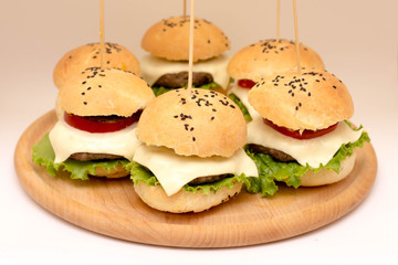 Tasty cheeseburgers on a wooden board
