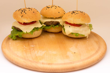 Tasty cheeseburgers on a wooden board