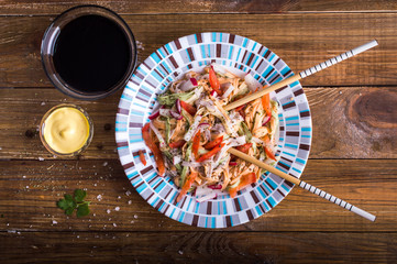 Colored Tagliatelle with vegetables on a wooden background