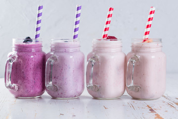 Selection of colorful detox berry drinks on wood background