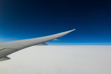 airplane wing above cloud in blue sky