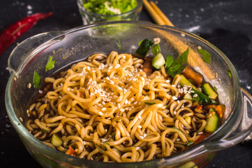 Noodles with vegetables on a wooden background