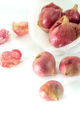 Red onions in mesh bag  isolated on white background