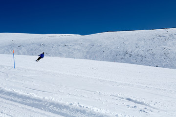 Snowboarder mountainside blue sky