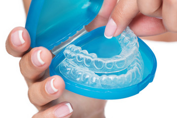Female arms showing clear aligners in case