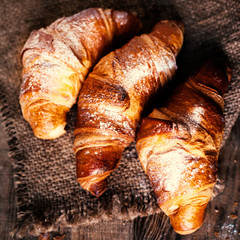 Fresh golden croissants on dark rustic  background