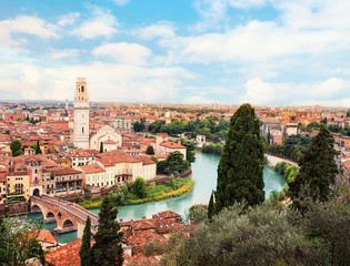 Fototapeta na wymiar Verona, Italy. Panoramic view to Bridge Ponte Pietra in Verona. Beautiful Sunny summer day panorama and blue sky may use as postcard or wallpaper