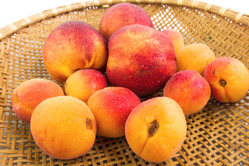 Apricots And Peaches In Plaited Bowl With Water Drops Closeup