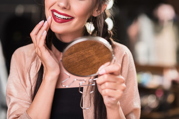 Beautiful young woman correcting makeup