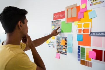 Man pointing at sticky notes in office