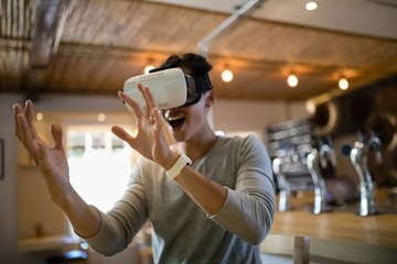 Man using virtual reality headset in restaurant - Powered by Adobe