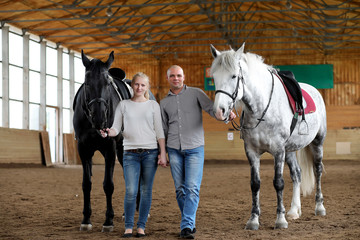 People on a horse training in a wooden arena