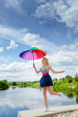 Girl jumping with a colorful umbrella