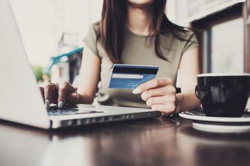 Young woman holding credit card and using laptop computer. Online shopping concept