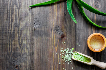Organic aloe vera cosmetics. Aloe vera leafs and spa salt on wooden table background top view copyspace