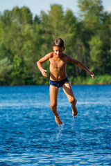 Young boy jumping into water