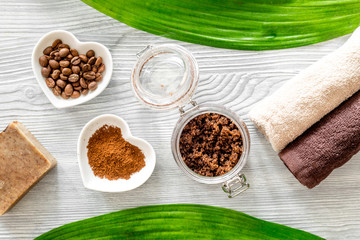 Organic coffee soap, coffee grains and towel on wooden background top view