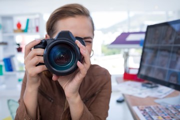 Naklejka premium Female executive taking a photograph from digital camera