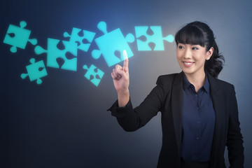 Beautiful Business Woman touching on Jigsaw sign on virtual screen