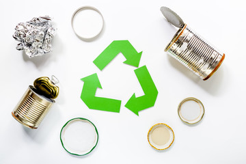 Paper recycle sign with steel garbage on white background top view