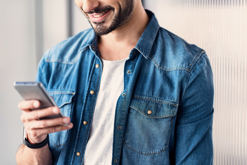 Cheerful guy messaging on phone