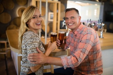 Happy couple having beer at bar counter