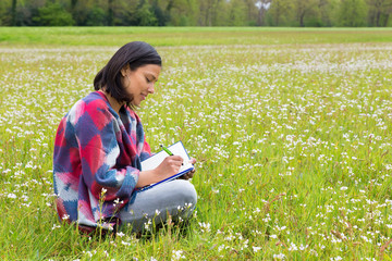 Woman writing in blooming dutch meadow