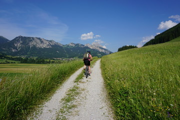 Fototapeta na wymiar Mountainbikerin vor Bergpanorama