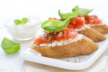 Bruschetta with cream cheese, tomatoes and basil